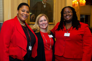 Three women in Cornell red pose for a photo