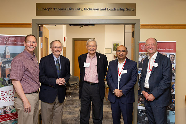 5 men standing side by side, smiling, at the entrance of a suite with a sign over the entrance that reads: L. Joseph Thomas Diversity, Inclusion, and Leadership Suite.